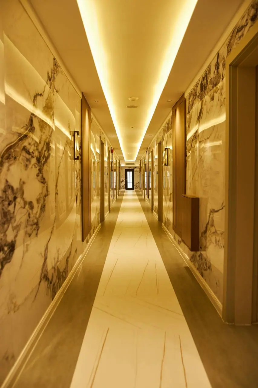 Golden-lit hotel corridor with marble walls