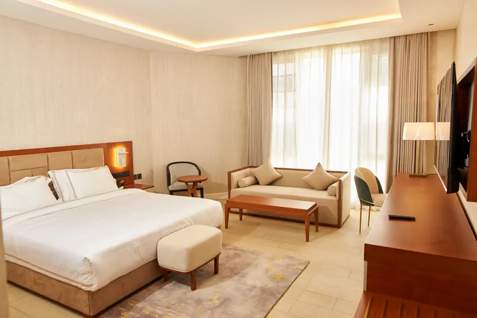 Executive Deluxe — king bed, sofa seating area and large windows with natural light