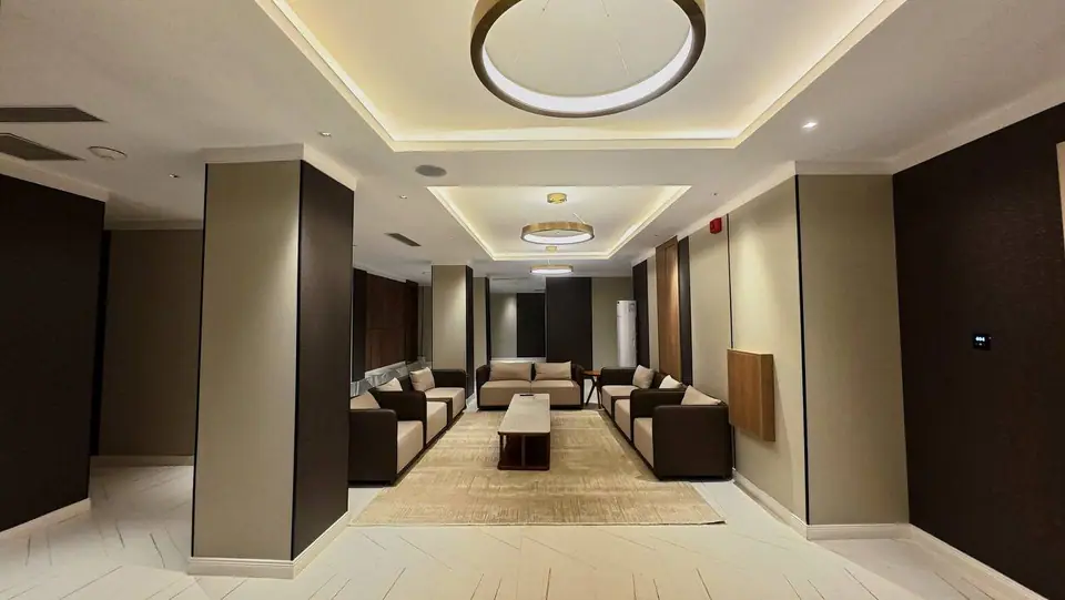 Presidential Suite — grand reception hall with coffered ceiling, ring pendants and full sofa arrangement